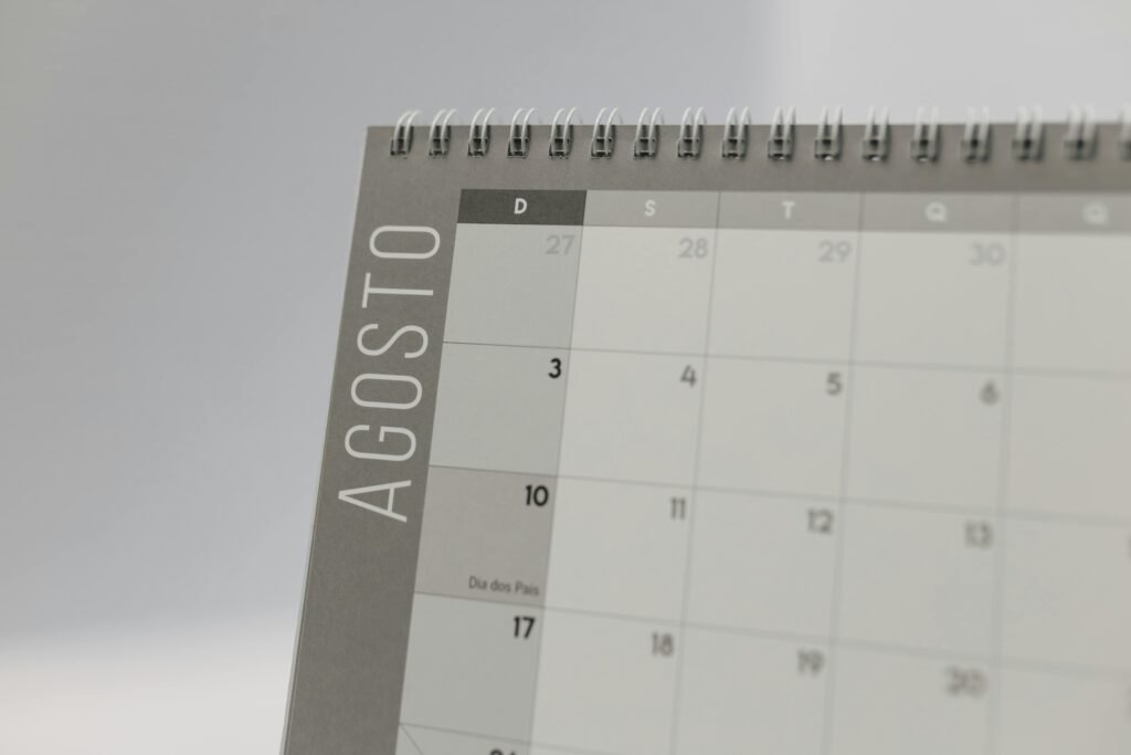 Detalhe de uma página de calendário com encadernação em espiral aberta em agosto, mostrando os dias 27 a 31 e uma etiqueta vertical com o mês na lateral Noite da Nostalgia no Uruguai