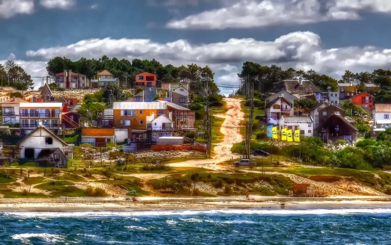 Vila de pescadores rústica na costa, um destino perfeito para quem vai viajar de carro para o Uruguai. A imagem mostra a arquitetura única de cabo polonio, com suas casas coloridas à beira-mar e estradas de terra charmosas.