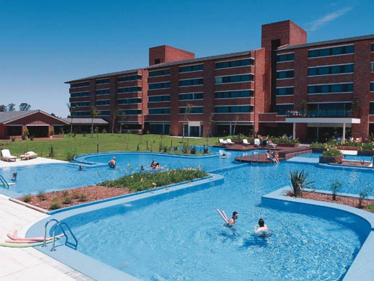 O conforto de um resort 5 estrelas nas termas uruguaias, como o Complexo de Salto Grande. A Brasileiros no Uruguai, sob a curadoria de Adriana Rodrigues, organiza roteiros exclusivos para esses refúgios de águas quentes, garantindo uma experiência de relaxamento completa para viajantes brasileiros.