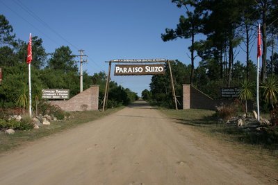avenida com placa de entrada para a região de Pueblo Suizo no Uruguai
