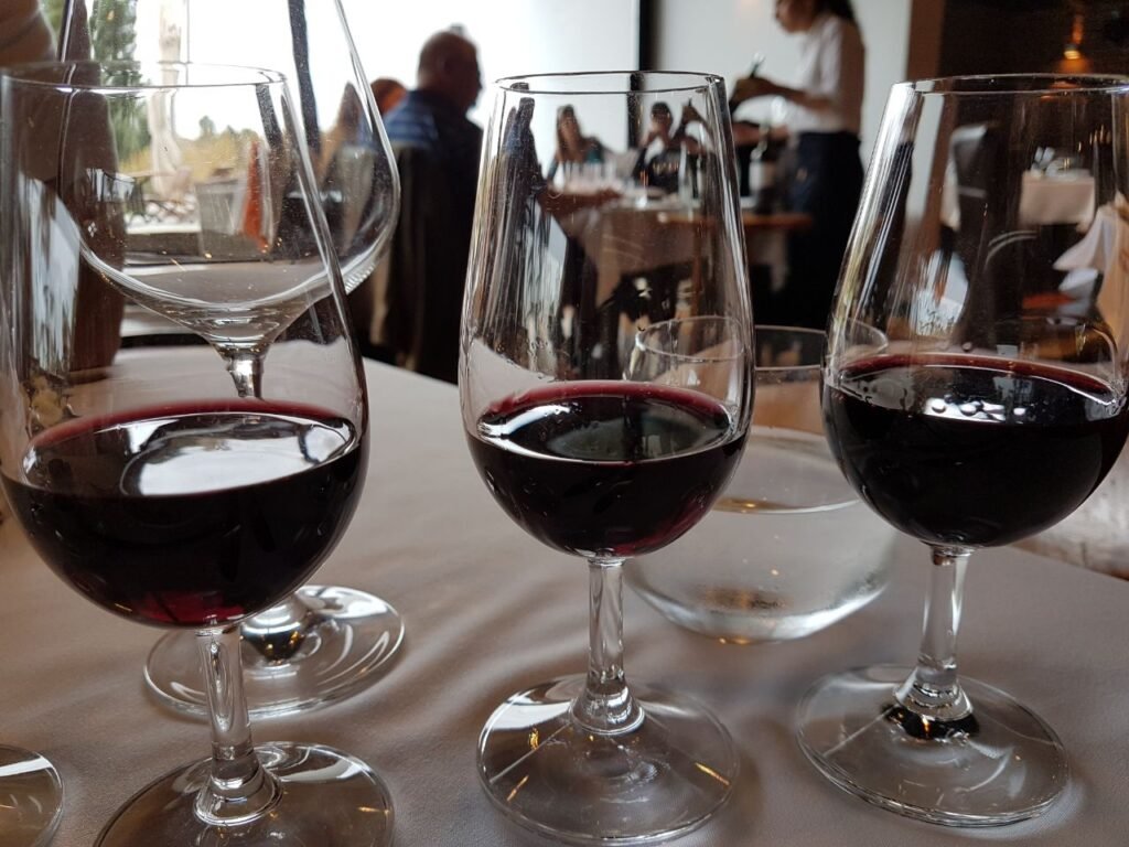 várias taças de vinho em destaque, com pessoas ao fundo roteiro Montevideo e Punta del Este