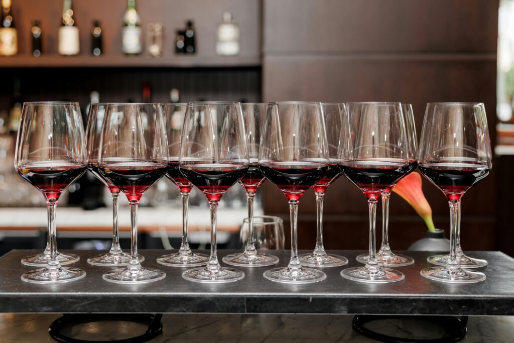 várias taças de cristal com vinho em cima de mesa de vidro puchero