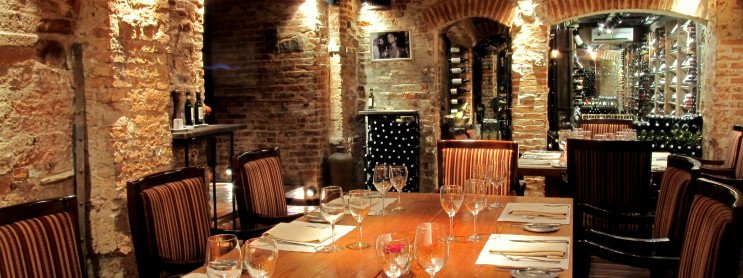 mesa de restaurante com cadeiras e utensílios puchero