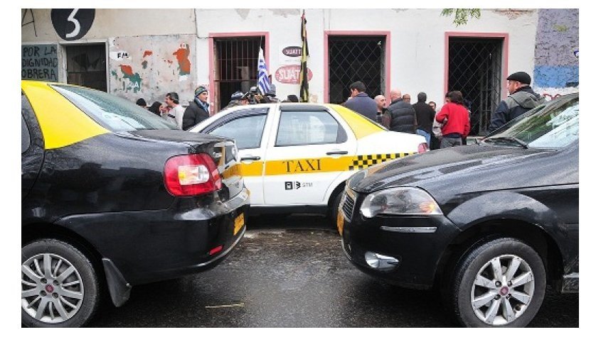 carros em circulação em avenida com táxi ao fundo quanto custa uma viagem para o Uruguai