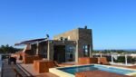 piscina, construção predial e céu azul ao fundo