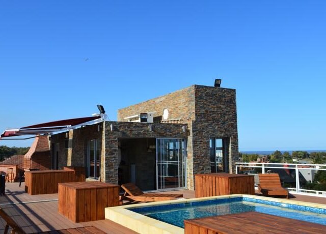 piscina, construção predial e céu azul ao fundo