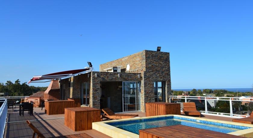 piscina, construção predial e céu azul ao fundo