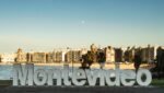letreiro de montevideo com praia e cidade ao fundo Letreiro de Montevideo em Pocitos