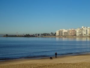 mar, com a cidade e o céu azul ao fundo