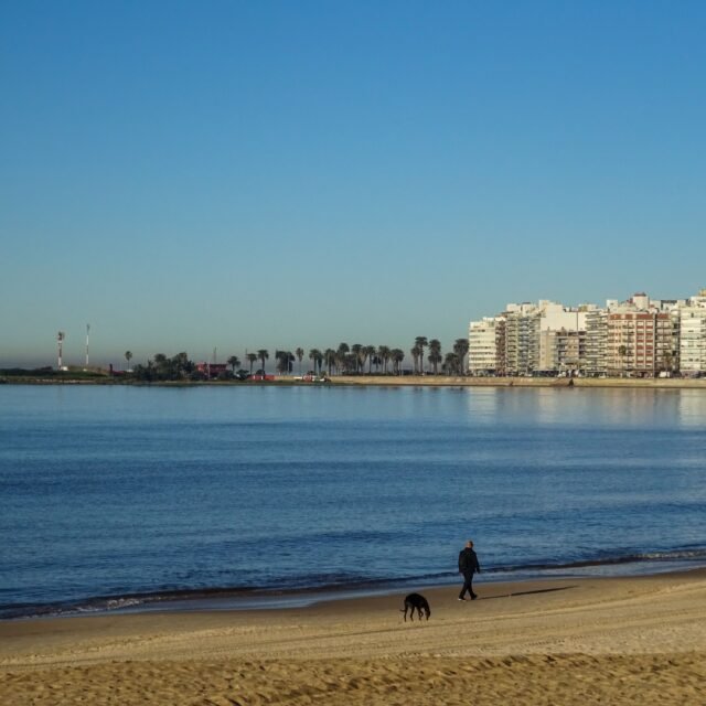 mar, com a cidade e o céu azul ao fundo