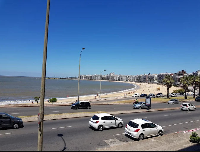 Avenida à beira da Praia de Pocitos com carros e a faixa de areia ao fundo