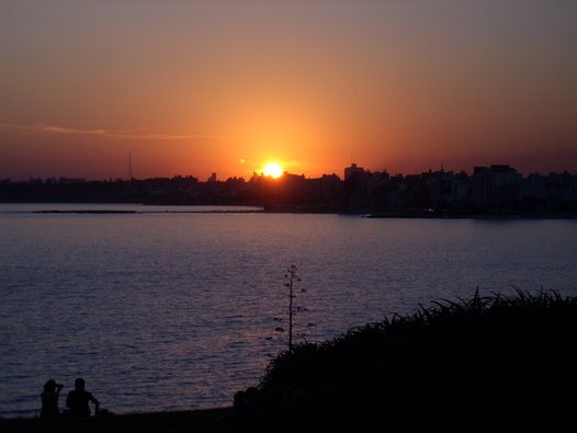 Pôr do sol na Praia de Punta Gorda com casal observando o horizonte de Montevideo