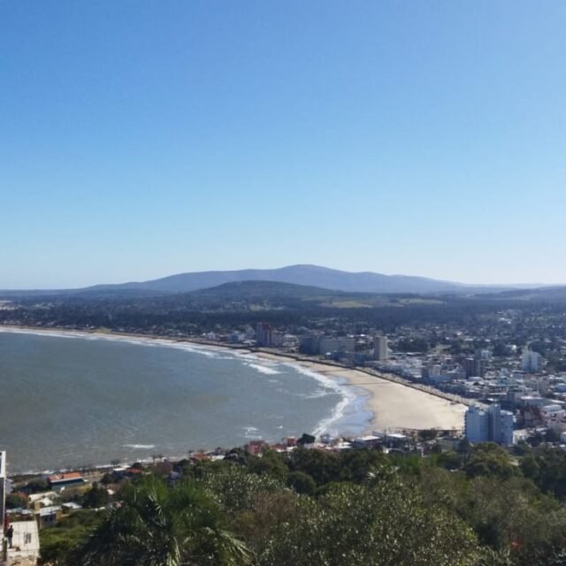 Vista do alto da baía e da Praia dos Ingleses com a cidade de Piriápolis e os morros ao fundo