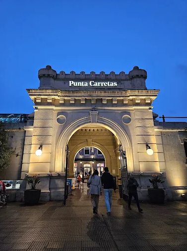 Portal iluminado com o letreiro Punta Carretas na entrada do shopping à noite