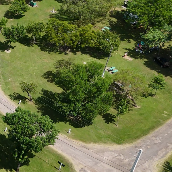 Vista aérea do gramado arborizado e área de camping nas Termas de Guaviyú