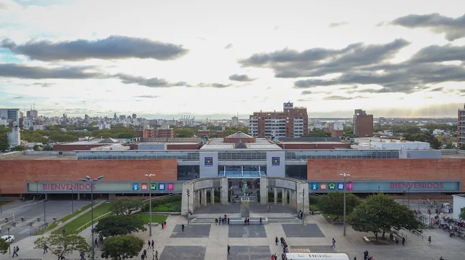 Fachada do shopping e terminal Tres Cruces com letreiro Bienvenidos e praça em frente