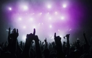 Luzes em violeta com mãos de pessoas em balada