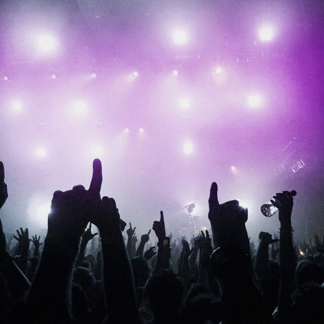 Luzes em violeta com mãos de pessoas em balada