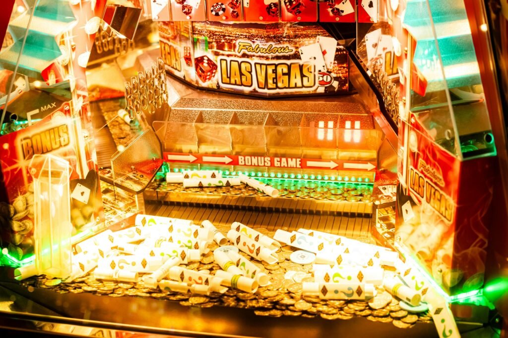 Interior de máquina caça-níqueis com tema de Las Vegas, com moedas brilhantes, rolos de papel coloridos e uma placa proeminente de 'JOGO BÔNUS' na parte inferior casino no Montevideo Shopping