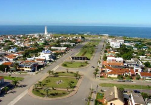 Vista aérea do centro de La Paloma com avenida arborizada e o farol ao fundo