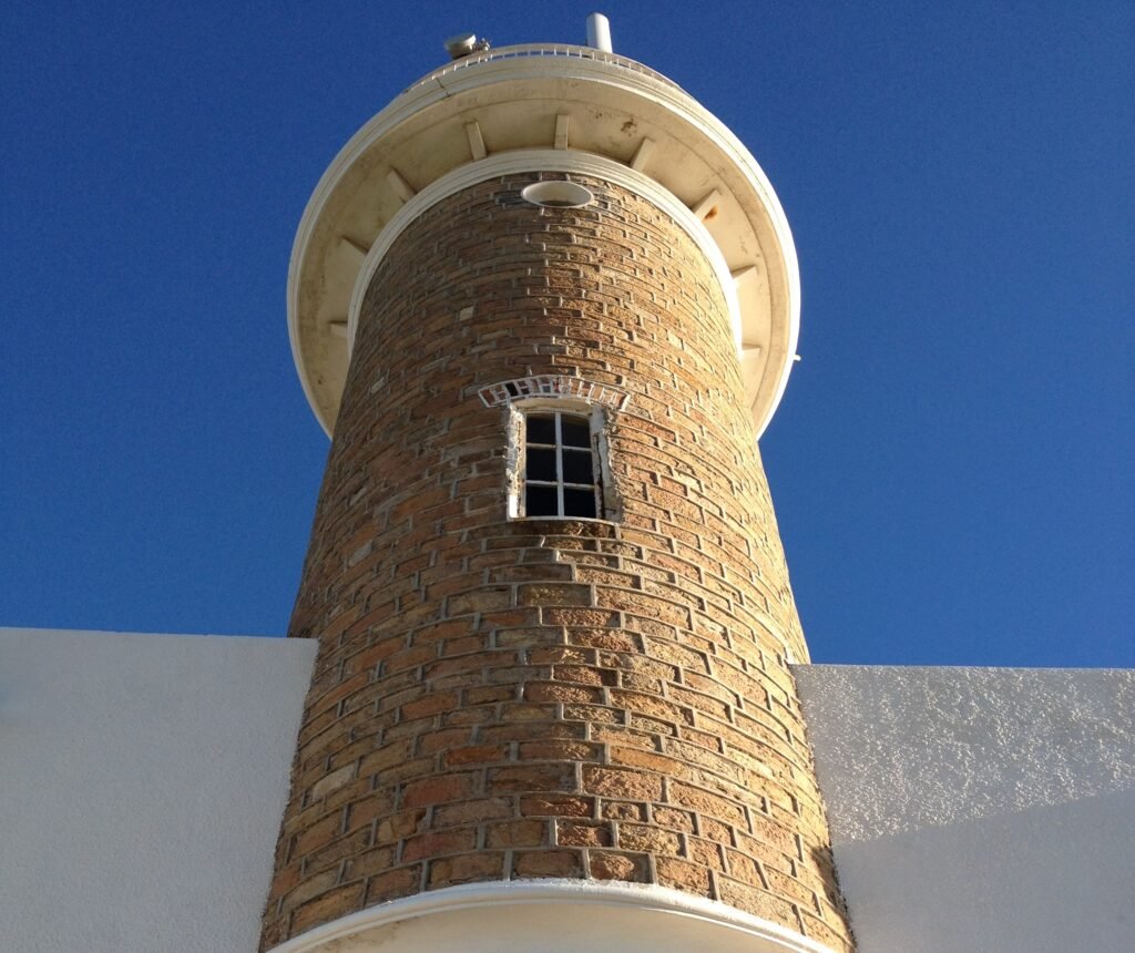 Farol de tijolos da Praia de Punta Carretas visto de baixo contra o céu azul