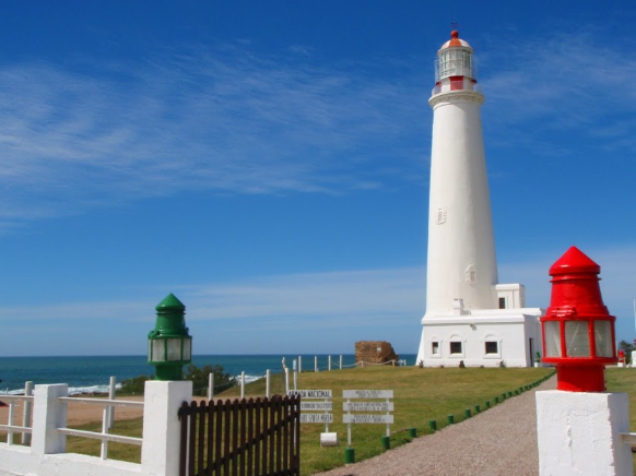Farol de La Paloma branco com lanternas verde e vermelha no portão de entrada
