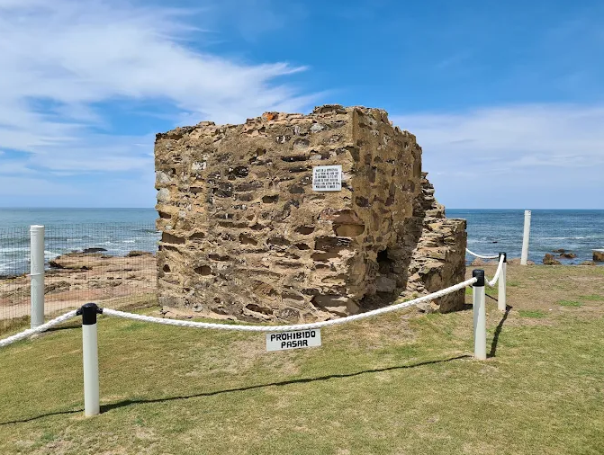 Ruínas de pedra do primeiro Farol de La Paloma cercadas por corda à beira-mar