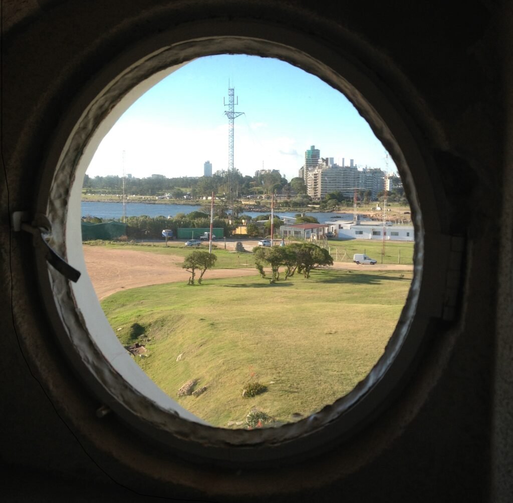 Vista da Praia de Punta Carretas e da orla de Montevideo por uma janela redonda do farol