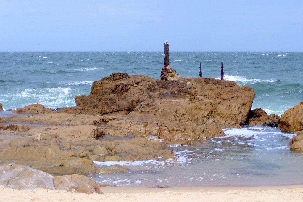 Formação rochosa com vestígios de estruturas antigas no mar agitado de La Pedrera