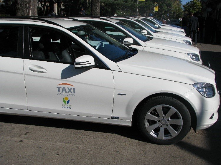 Fileira de táxis brancos do Aeroporto estacionados em uma rua, prontos para receber passageiros que estão chegando ao Uruguai pela primeira vez.