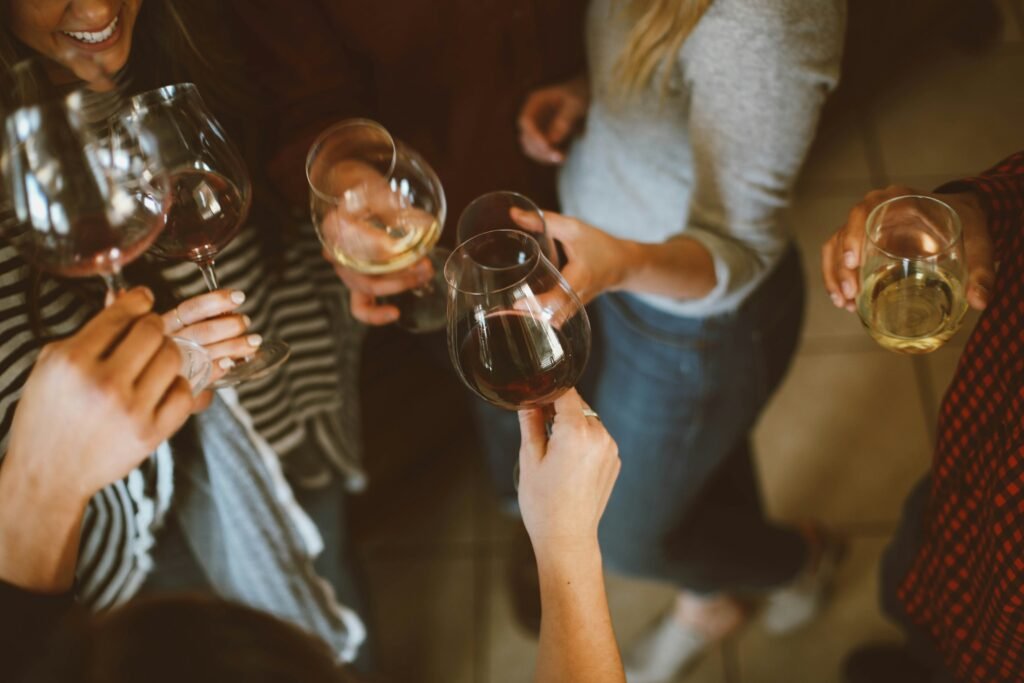 Grupo de pessoas brindando com taças de vinho, visto de cima.