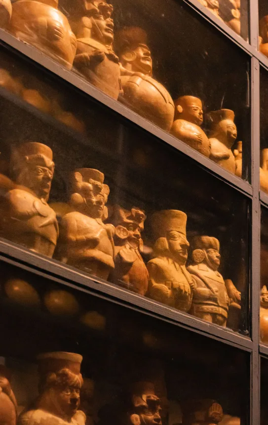 Prateleiras com estatuetas de ceramica precolombiana expostas em vitrine