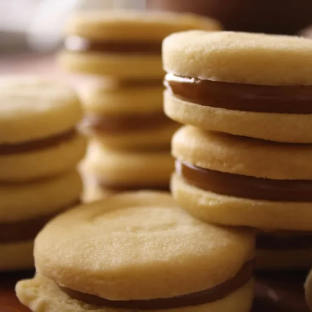 Alfajores empilhados com recheio de doce de leite entre duas massas macias