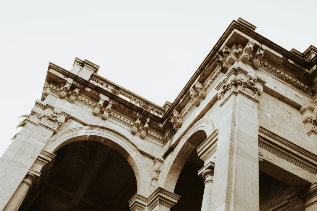 Frontao e arco de pedra clara de um edificio monumental, vistos de baixo