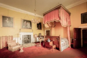 Quarto com mobiliario de epoca, cama de dossel e lareira em casa historica