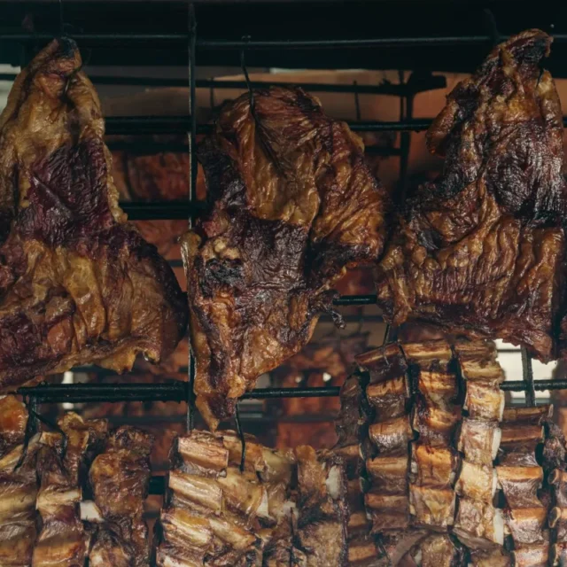 Cortes de carne assando lentamente na grelha de uma parrilla