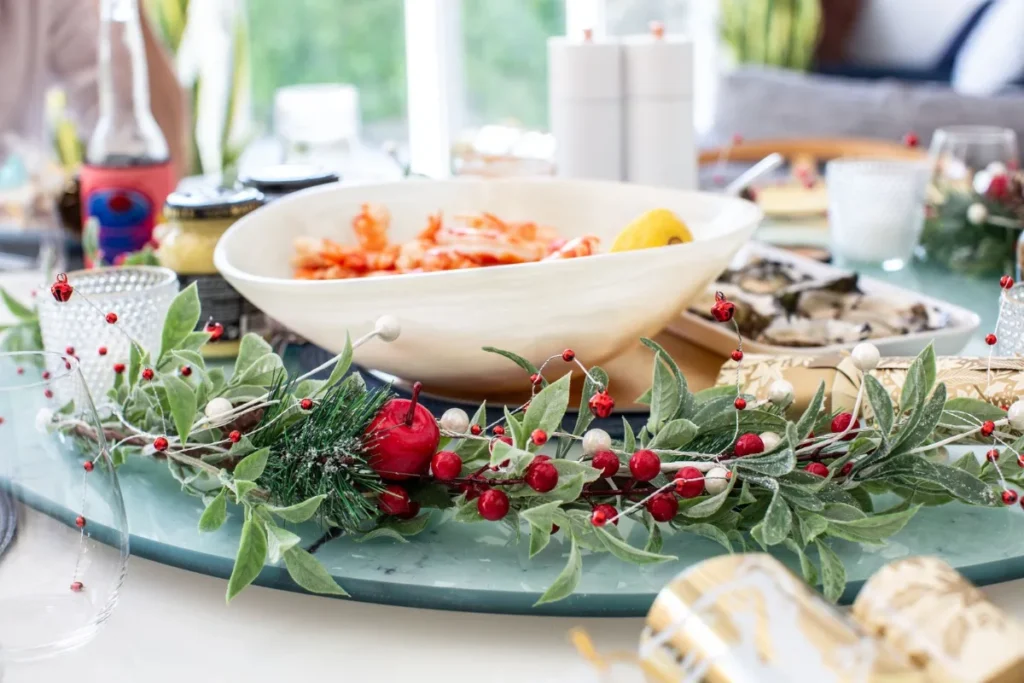 Travessa de frutos do mar e decoração natalina sobre a mesa da ceia