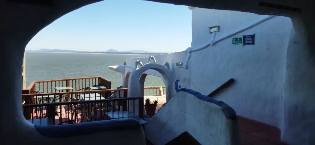 Arco branco da Casapueblo emoldurando o terraco e o mar, onde acontece a Cerimonia do Sol