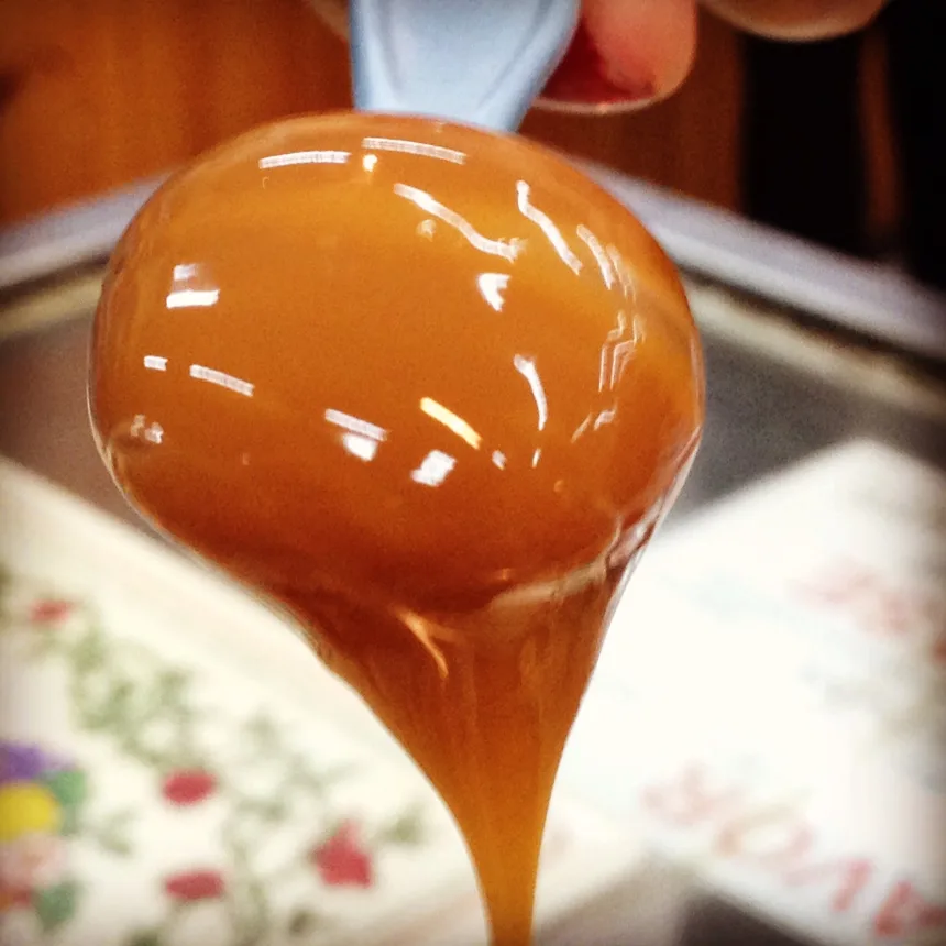 Doce de leite escorrendo da colher, recheio classico dos churros uruguaios