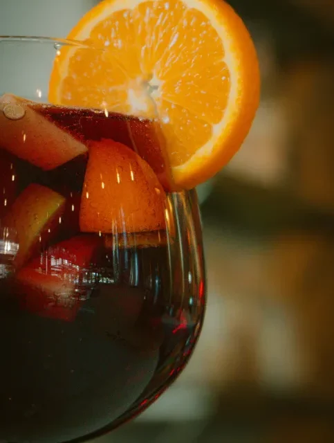 Jarra de bebida com frutas e fatias de laranja, servida gelada no verao