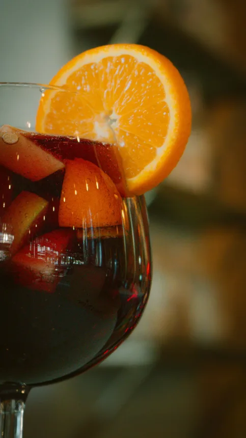 Jarra de bebida com frutas e fatias de laranja, servida gelada no verao