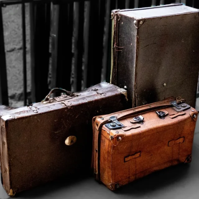 Malas de viagem antigas de couro empilhadas, evocando a chegada dos imigrantes
