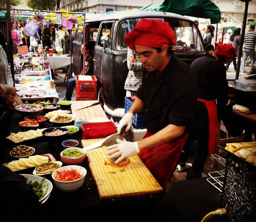 Vendedor preparando comida de rua em uma barraca da feira