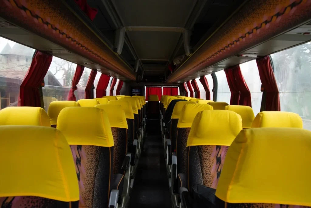 Interior de um onibus de viagem com poltronas vermelhas