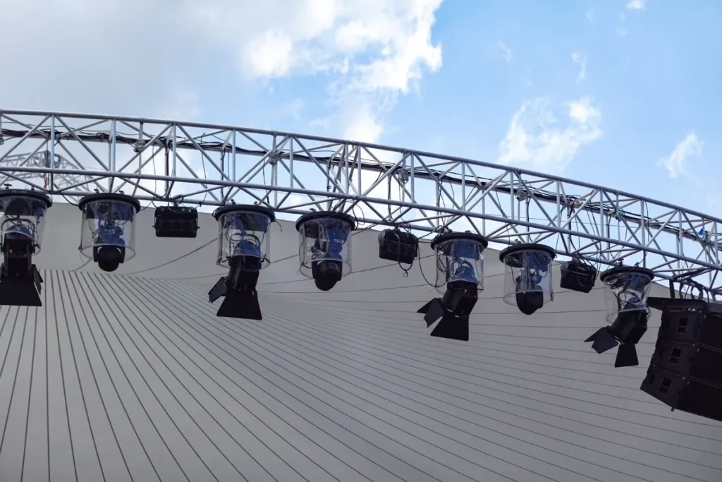 Estrutura de refletores de um palco ao ar livre sob ceu azul