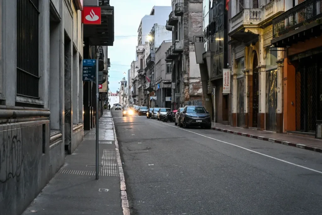 Rua do centro de Montevideo ao entardecer, com predios historicos