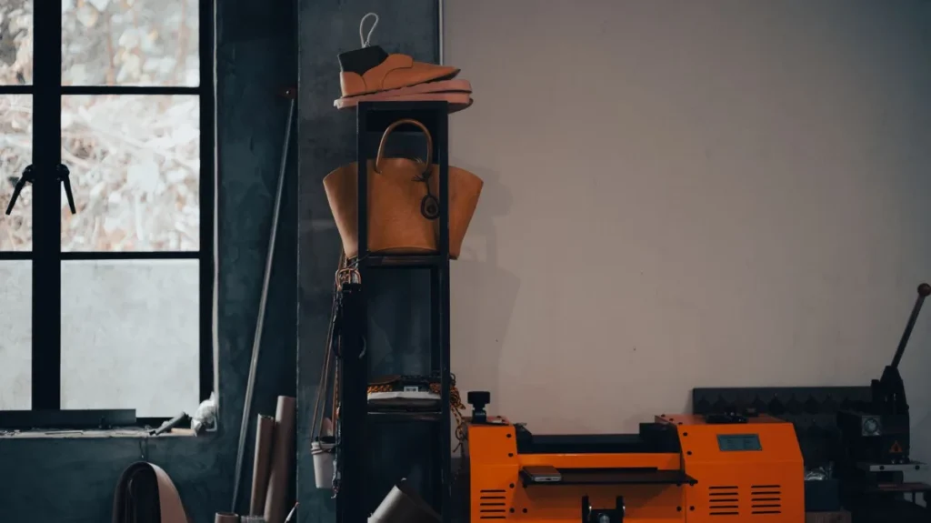 Interior de uma oficina de couro com bolsas expostas e ferramentas de trabalho