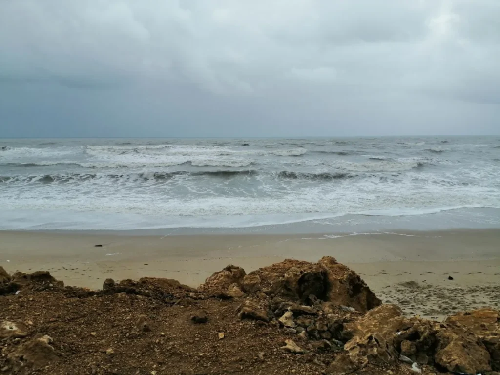 Costa rochosa do Atlantico com ondas quebrando sob ceu nublado