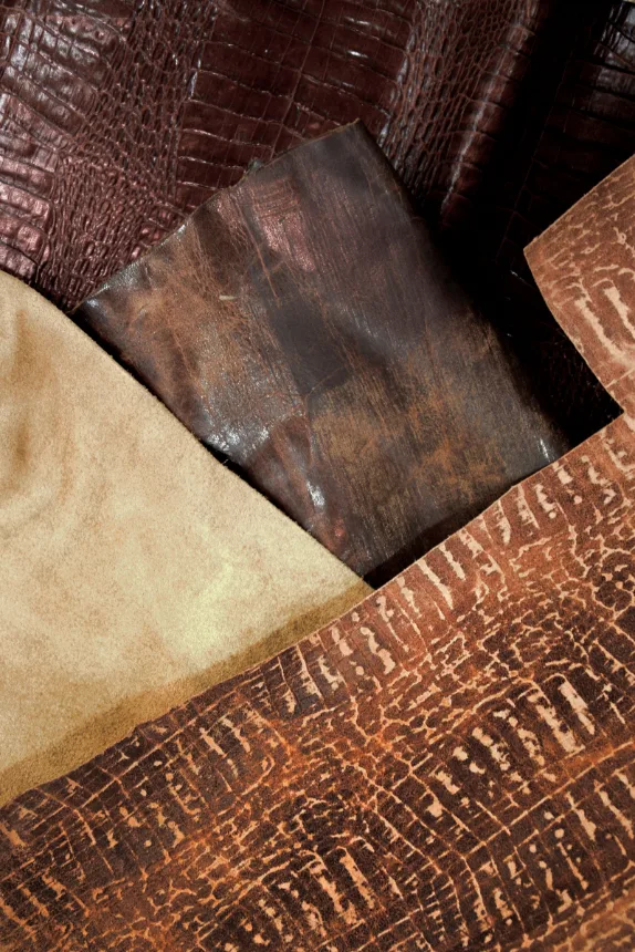 Peles de couro curtido em tons de marrom, materia-prima das pecas artesanais