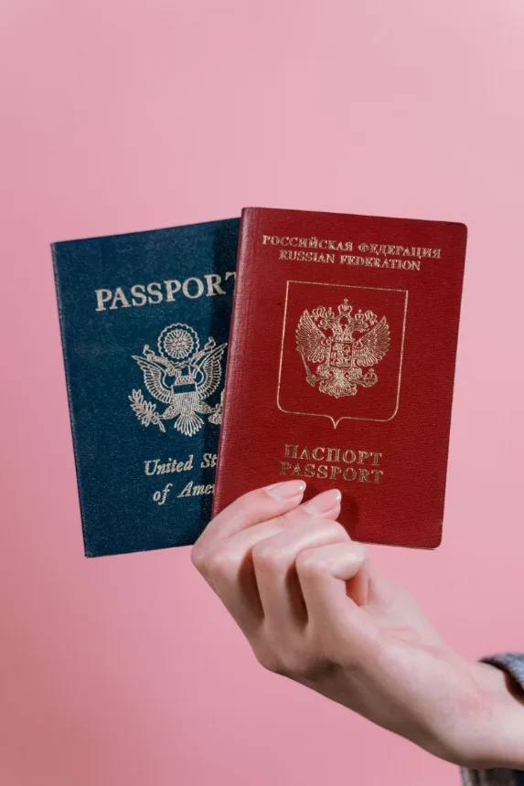 Duas maos segurando passaportes antes de uma viagem internacional